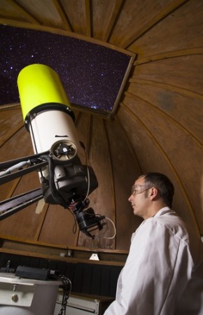 Astrônomo observando corpos celestes com um telescópio. Foto: Henk Stolk / Shutterstock.com